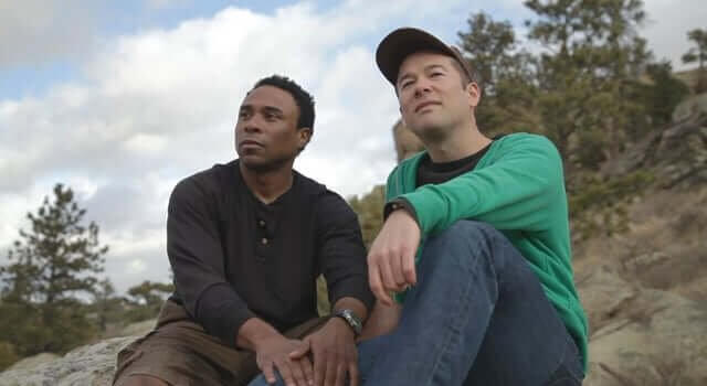 Still from "Red Lodge" - Jordan and Dave hiking in the woods, looking off into the distance