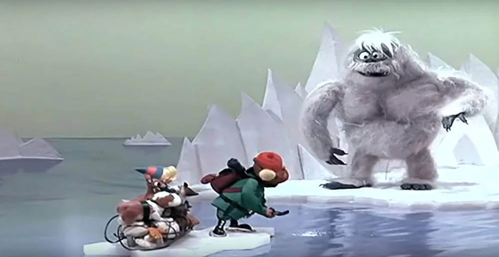 Still from "Rudolph the Red-Nosed Reindeer" - Yukon hollers and attempts to frighten away the Abominable Snowman from Rudolph and Hermey as they float away on an iceberg