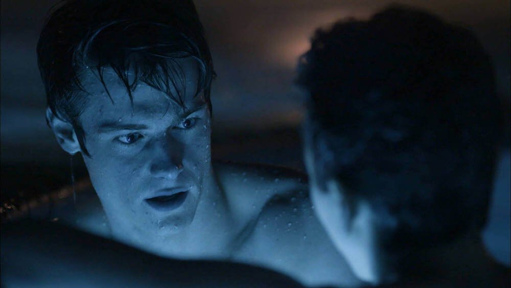 Still from “Tomorrow” - Trevor and Clark chill in the pool, reflected by blue light of the water